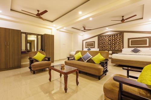 钦奈Hotel Comfort Park - Opposite Sri Ramachandra Medical College Porur的酒店客房配有一张床、一张沙发和椅子。