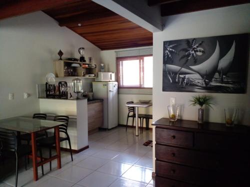 皮帕Sol da Pipa Flats Bosque da Praia的厨房以及带桌子和冰箱的用餐室
