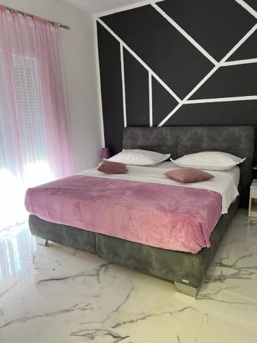 奥库格哥恩基apartment Vujcic 2的一间卧室配有一张大床,提供紫色床单和枕头