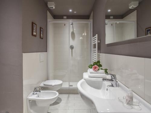 佛罗伦萨拉法里纳公寓酒店的一间带两个盥洗盆、淋浴和卫生间的浴室