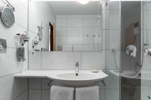 FensterbachHotel Wolfringmühle的白色的浴室设有水槽和淋浴。