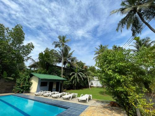 乌纳瓦图纳Villa Gaetano Unawatuna的一个带游泳池和躺椅的度假胜地