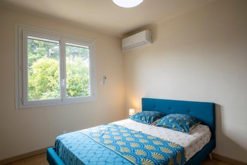 阿维尼翁Villa de 200 m2 avec piscine proche du centre-ville的一间卧室设有蓝色的床和窗户。