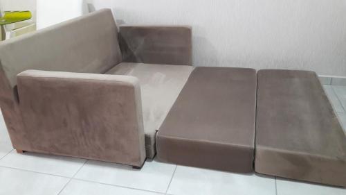 伊瓜苏Ap flat central- ar, garagem e ótima localização的客厅里一张棕色沙发