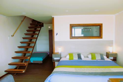 瓜纳切洛斯WANNAQUEROS SUITES的一间卧室设有一张床和一个螺旋楼梯