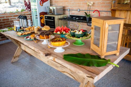 德尔菲诺波利斯Casa Erva Doce Pousada的一张木桌,上面放着一大堆食物