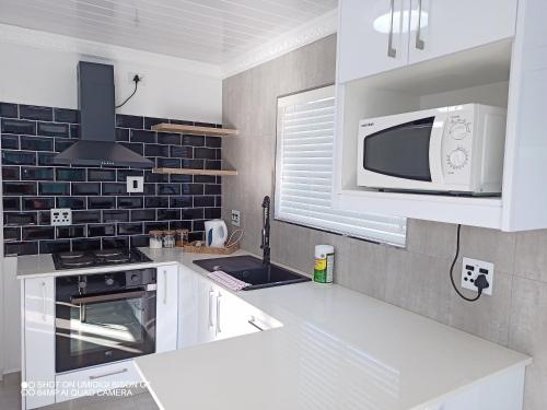 开普敦Palm Tree的厨房配有白色橱柜和微波炉