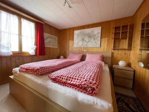 阿克斯普Chalet Chutzli的一间卧室配有一张红色和白色的棉被床