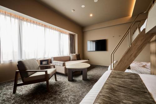 鹿儿岛FAV HOTEL KAGOSHIMACHUO的一间带双层床的卧室和一间客厅