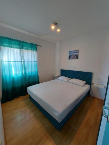 普特尼科维奇Apartmani Vlahušić的一间卧室配有一张大床和蓝色床头板