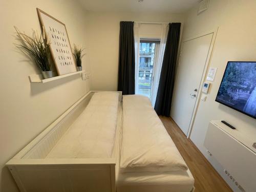 利勒斯特罗姆Newer apartment, with all you needs! 25 minutes to Oslo City or OSL Airport!的配有电视的客房内的一张大床