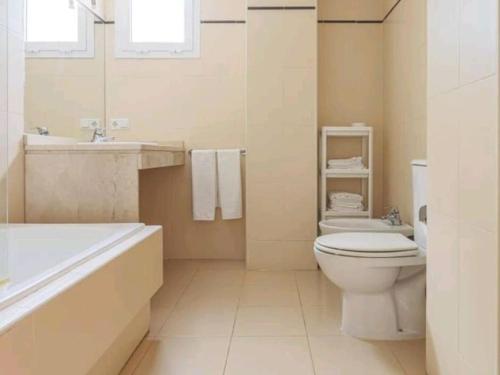 拉阿尔加瓦Alojamiento con piscina y parking en Sevilla的浴室配有卫生间、浴缸和水槽。