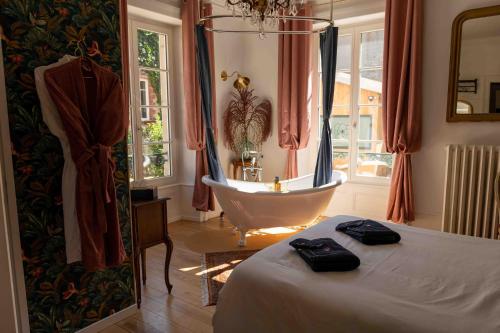 蒙贝利亚尔Le Parc du Magnolia的一间带浴缸、床和浴缸的卧室