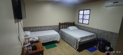 BarcelosEL DORADO POUSADA的一间小卧室,配有两张床和窗户