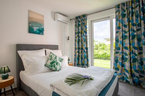 圣弗朗索瓦Hôtel Guadeloupe Palm Suites的一间卧室设有一张床和一个大窗户