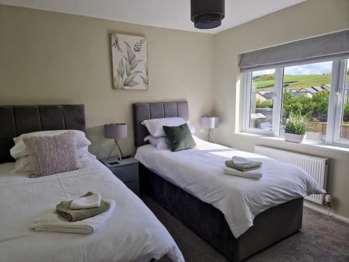 肯德尔'Benson View' - 2 bedroom Lake District home的一间卧室设有两张床和窗户。