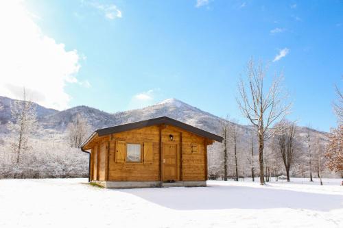 普卢日内Vikendice Gornja Brezna - Mountain cabin Gornja Brezna的雪中小木屋,后方是山