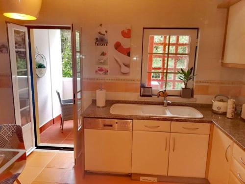 辛特拉Enjoy Beloura!的厨房设有水槽和滑动玻璃门