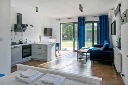 皮什Apartamenty Zielona Lipka的厨房以及带蓝色沙发的客厅。
