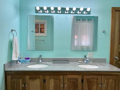 巴斯蒂门多斯Sunset View的浴室设有两个水槽和蓝色的墙壁。