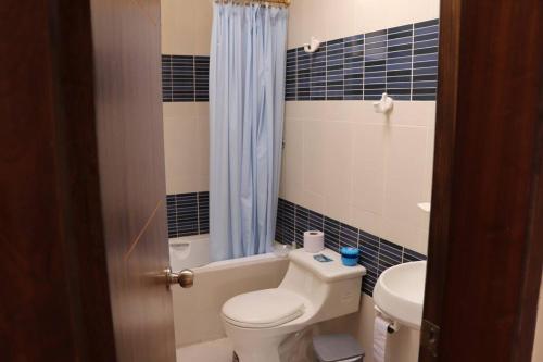 昆卡Cozy and Spacious Home with Incredible Location的浴室配有卫生间、浴缸和水槽。