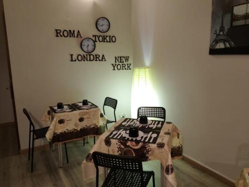 帕尔马HOTEL Via Emilia Ovest 224 SELF CHECK-IN的一间墙上配有桌椅和时钟的房间