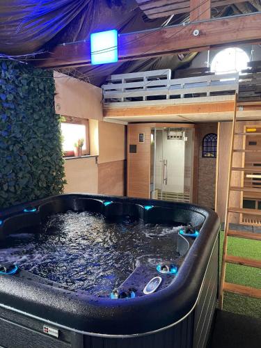 FloreffeCasawellness nuit insolite avec jacuzzi的一座带按摩浴缸的客房,位于一座建筑中