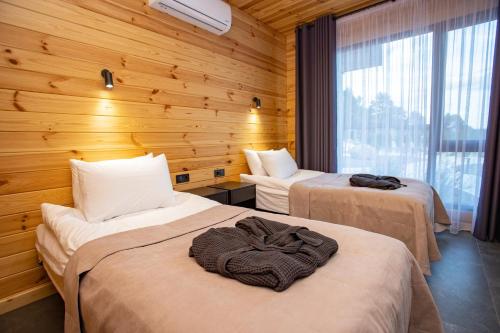 切尔卡瑟Perlyna Resort的木墙客房的两张床