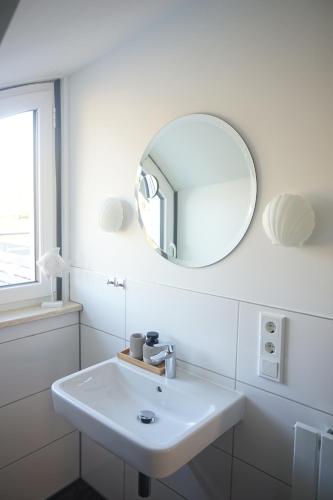 文斯托夫Landhotel Strandallee的白色的浴室设有水槽和镜子
