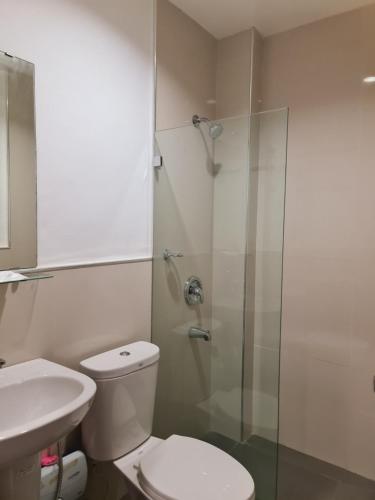卡利博Grace & RB Hotel的一间带卫生间和玻璃淋浴间的浴室
