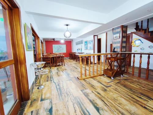 里约热内卢Marambaia Mar的一间铺有木地板的客房,并在大楼内设有桌子。