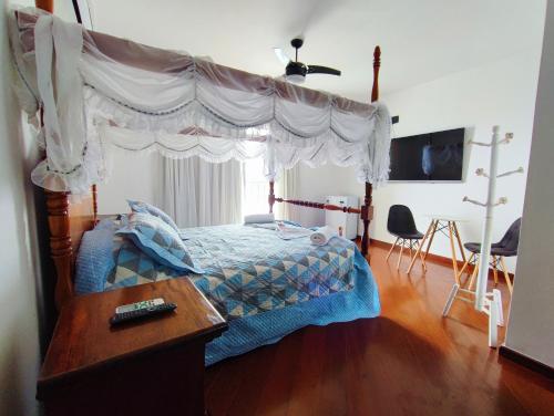里约热内卢Marambaia Mar的卧室配有一张华盖床,铺有木地板