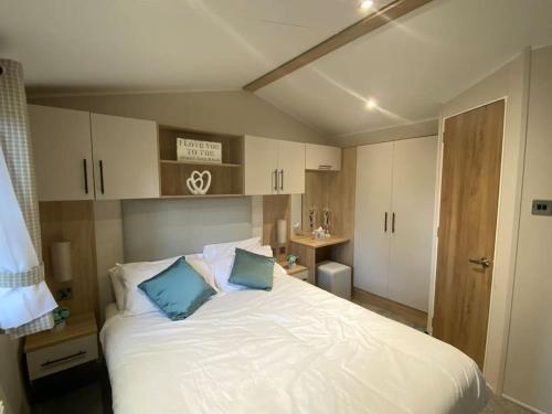 海斯廷斯Coghurst Hall Holiday Home Sleeps 6, 2 bedrooms的卧室配有带蓝色枕头的大型白色床