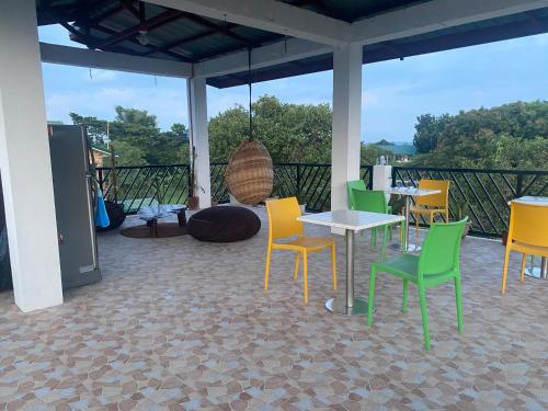 阿拉米诺斯Traditional Filipino Home near 100 Islands Wharf的庭院设有黄色和绿色的椅子和桌子。