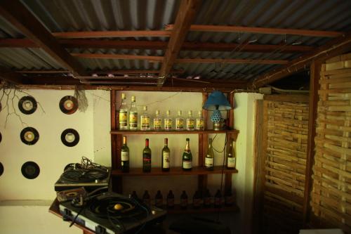 安东尼奥港La Familia Guest House and Natural Farm的墙上装有瓶装葡萄酒和时钟的架子
