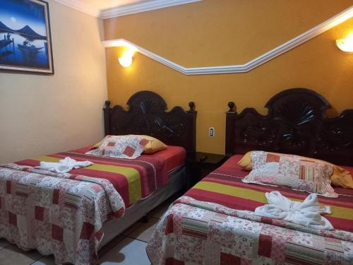 圣佩德罗拉拉古纳Hotel Tinamit的一间客房内配有两张床的房间