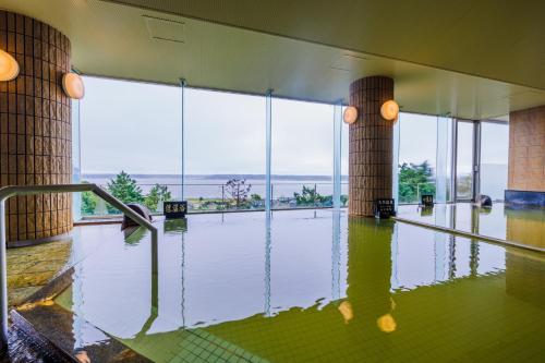 ItakoKAMENOI HOTEL Itako的客房铺有充气地板,设有大窗户。