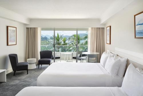 汉密尔顿岛珊瑚景酒店的酒店客房带一张床、一张桌子和椅子