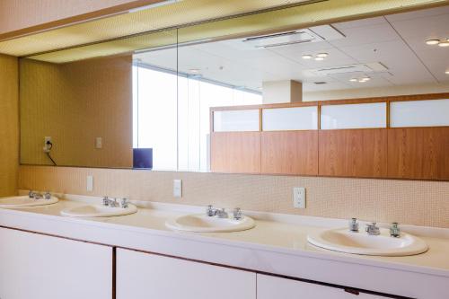 ItakoKAMENOI HOTEL Itako的一间带三个水槽和大镜子的浴室