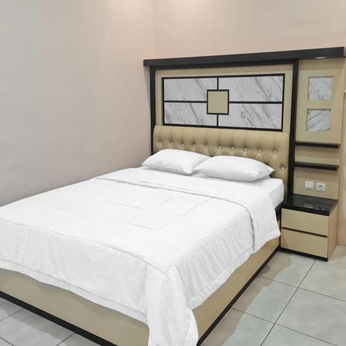 SampitRedDoorz @ Jalan Nyai Enat Sampit的一间卧室配有一张带白色床单的床和一扇窗户。
