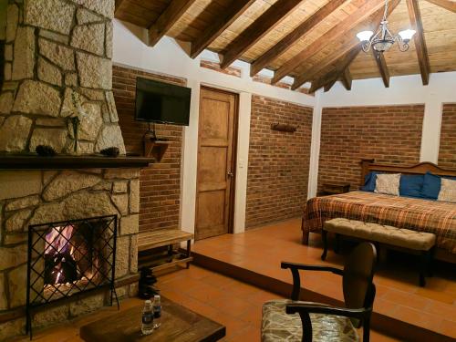 瓦斯卡坎波CABAÑAS LOS LAURELES的一间卧室设有壁炉、一张床和一台电视机。