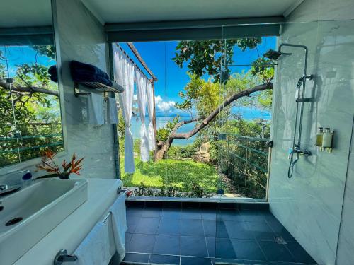 泰泰The Dream Beach Resort的带淋浴和盥洗盆的浴室以及窗户。