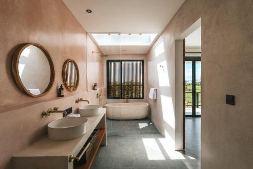 海神庙Botanique Villa & Studio的浴室设有2个水槽、浴缸和镜子
