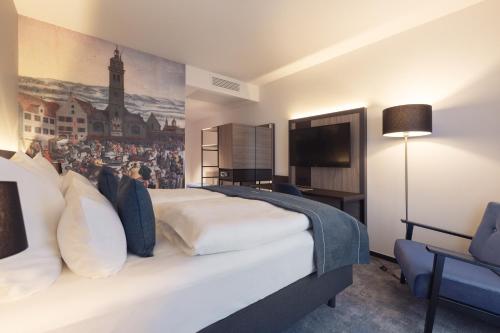 NeusäßSelect Hotel Augsburg的卧室配有一张白色大床,墙上挂有绘画作品