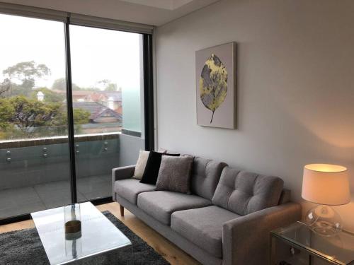 悉尼Beautiful Apartment in Chatswood的带沙发和玻璃桌的客厅