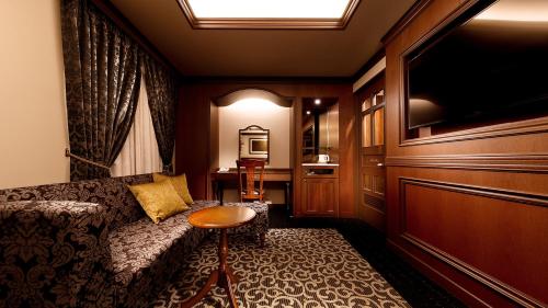 广岛Hiroshima Grand Intelligent Hotel的客厅配有沙发和桌子。