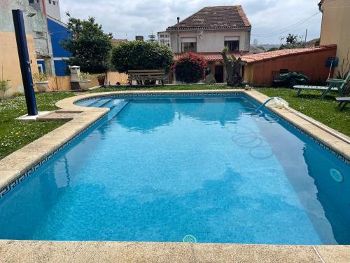 维戈Apartamento con piscina privada的蓝色的游泳池,后面有房子