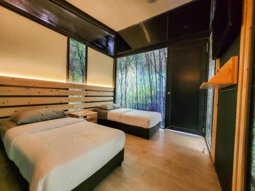 努沙再也X Park Iskandar Puteri的一间卧室设有两张床和大窗户