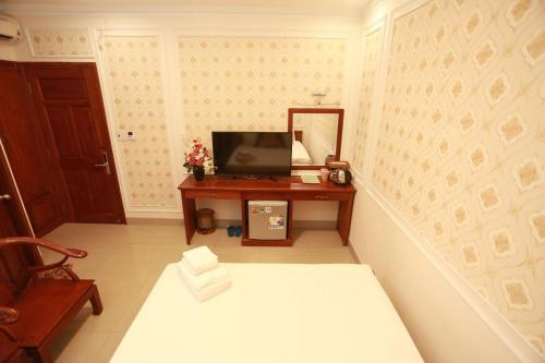 胡志明市THANH TAI HOTEl 1的配有电视和带镜子的桌子的房间