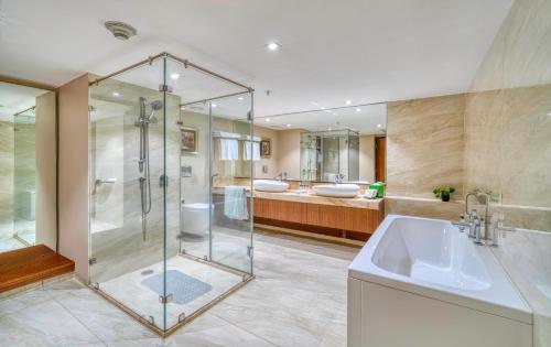 加尔各答加尔各答机场假日酒店的一间带玻璃淋浴和水槽的浴室